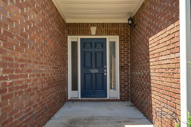 Covered front entry with a navy front door