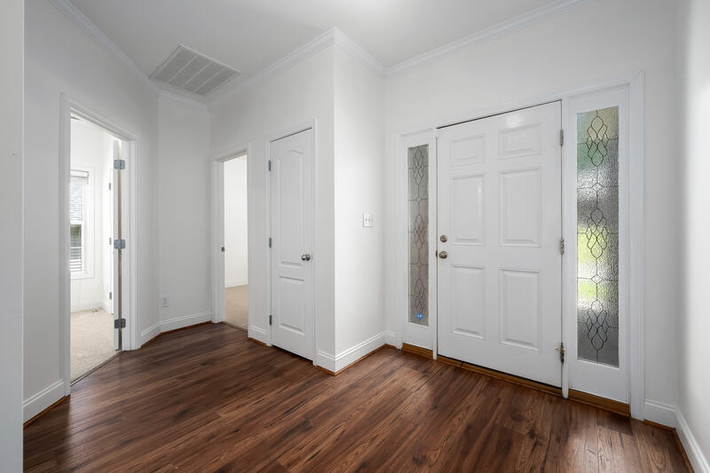 Entry foyer with hardwood floors and a leaded glass sidelight