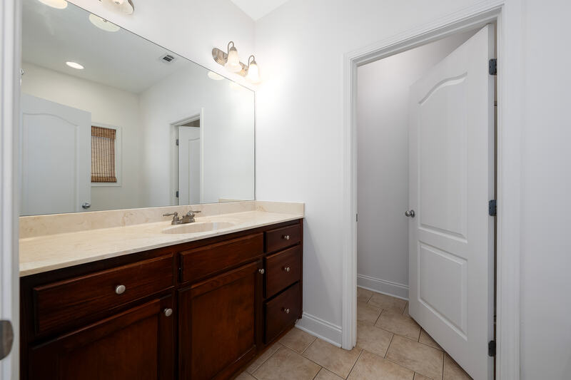 Primary bath with a wood vanity and solid surface top