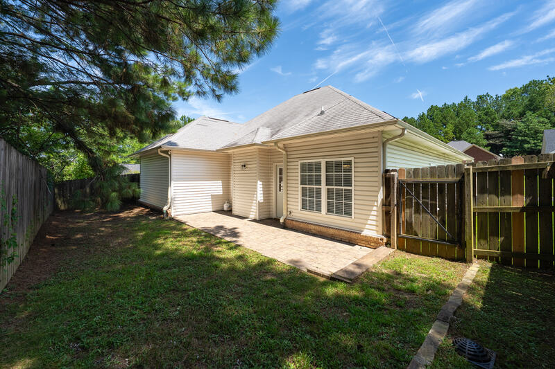 Back of the home with a paver patio and fenced yard
