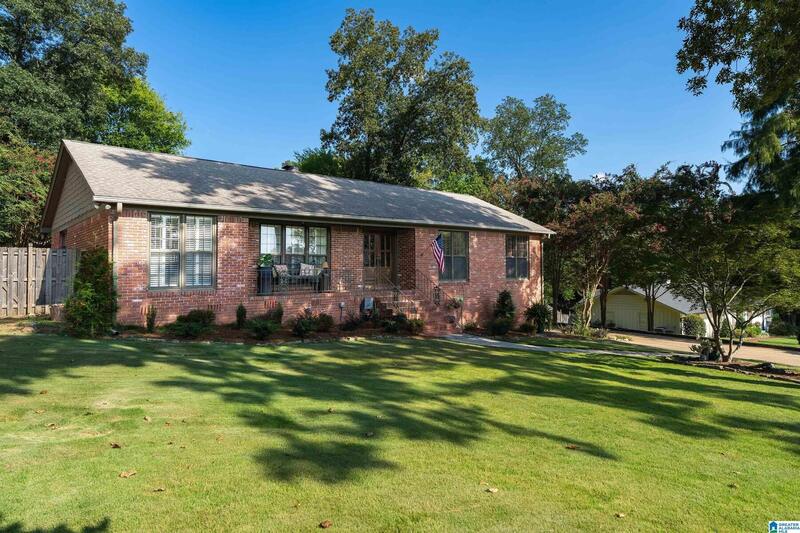 Front elevation of the brick home from the side lawn