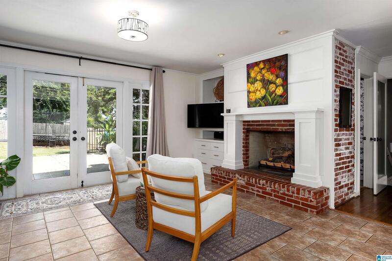 Family room with a brick fireplace and French doors to the patio