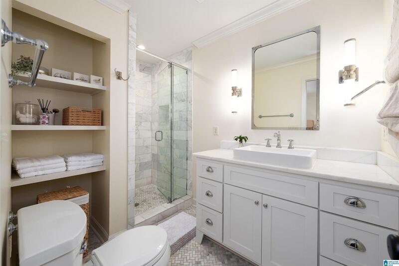 Updated primary bath with a white vanity and glass shower